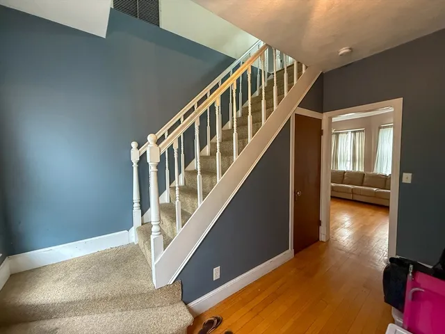 a view of entryway and hall with wooden floor