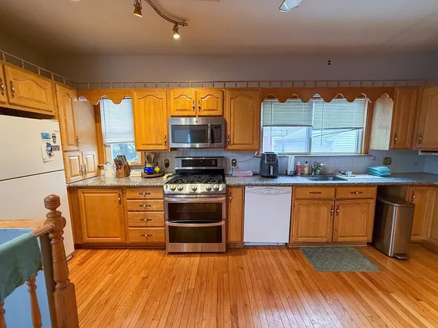 a kitchen with stainless steel appliances granite countertop a stove a sink and a microwave