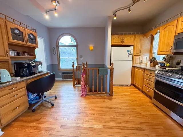 a living room with furniture flat screen tv and kitchen view