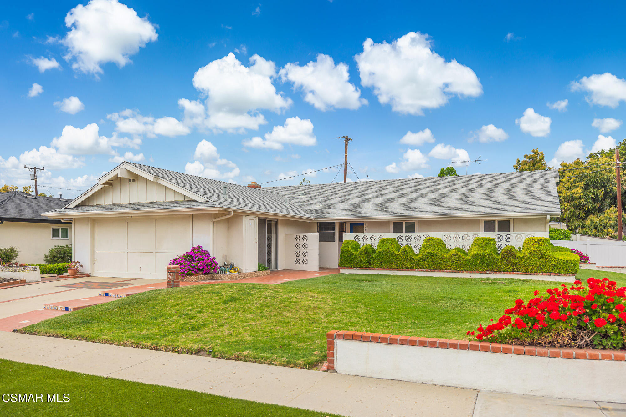 a front view of a house with a big yard and a large tree