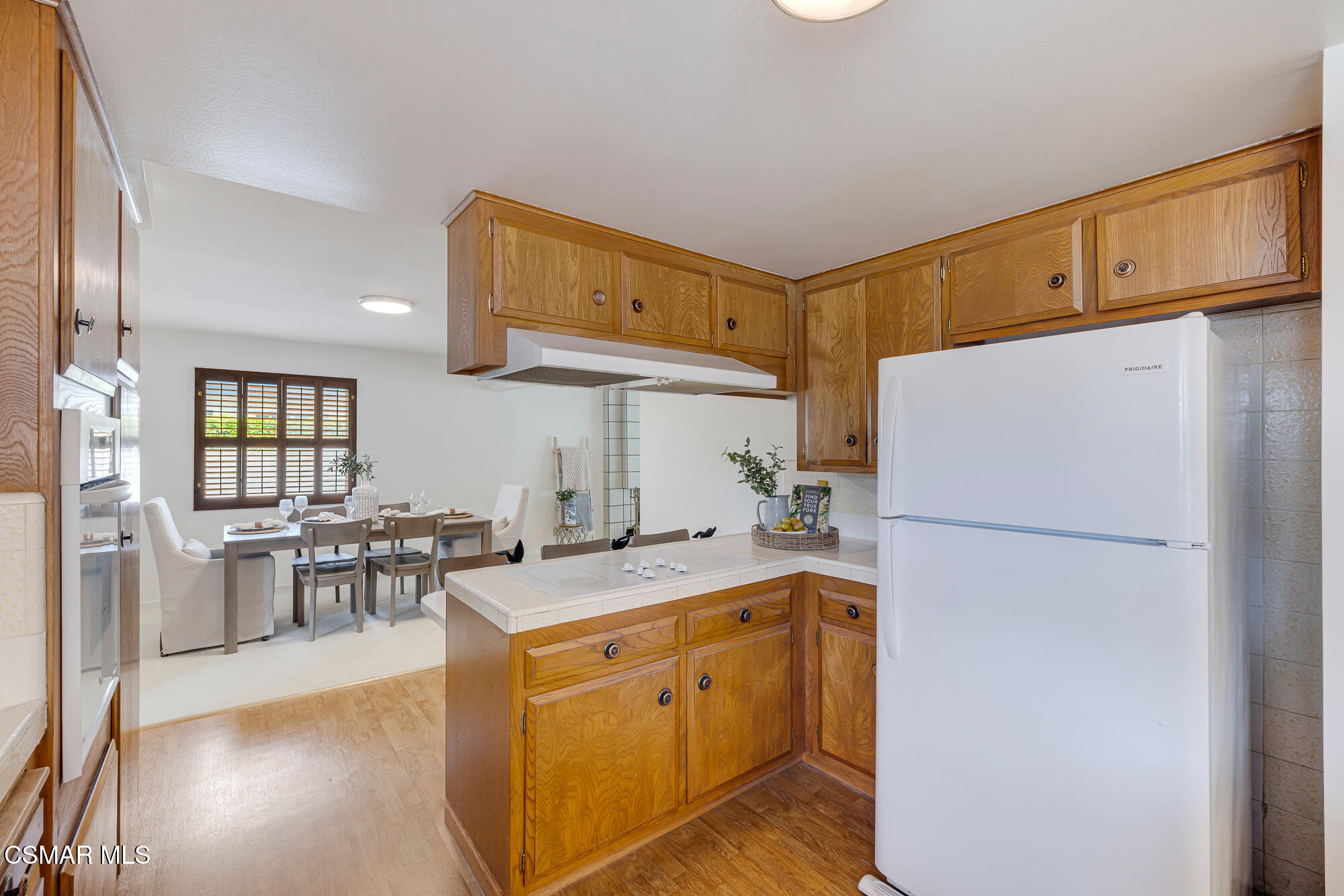 3491 Rivermore Street Camarillo, CA 93010 - Photo 12 of 49 a kitchen with a sink a refrigerator and chairs
