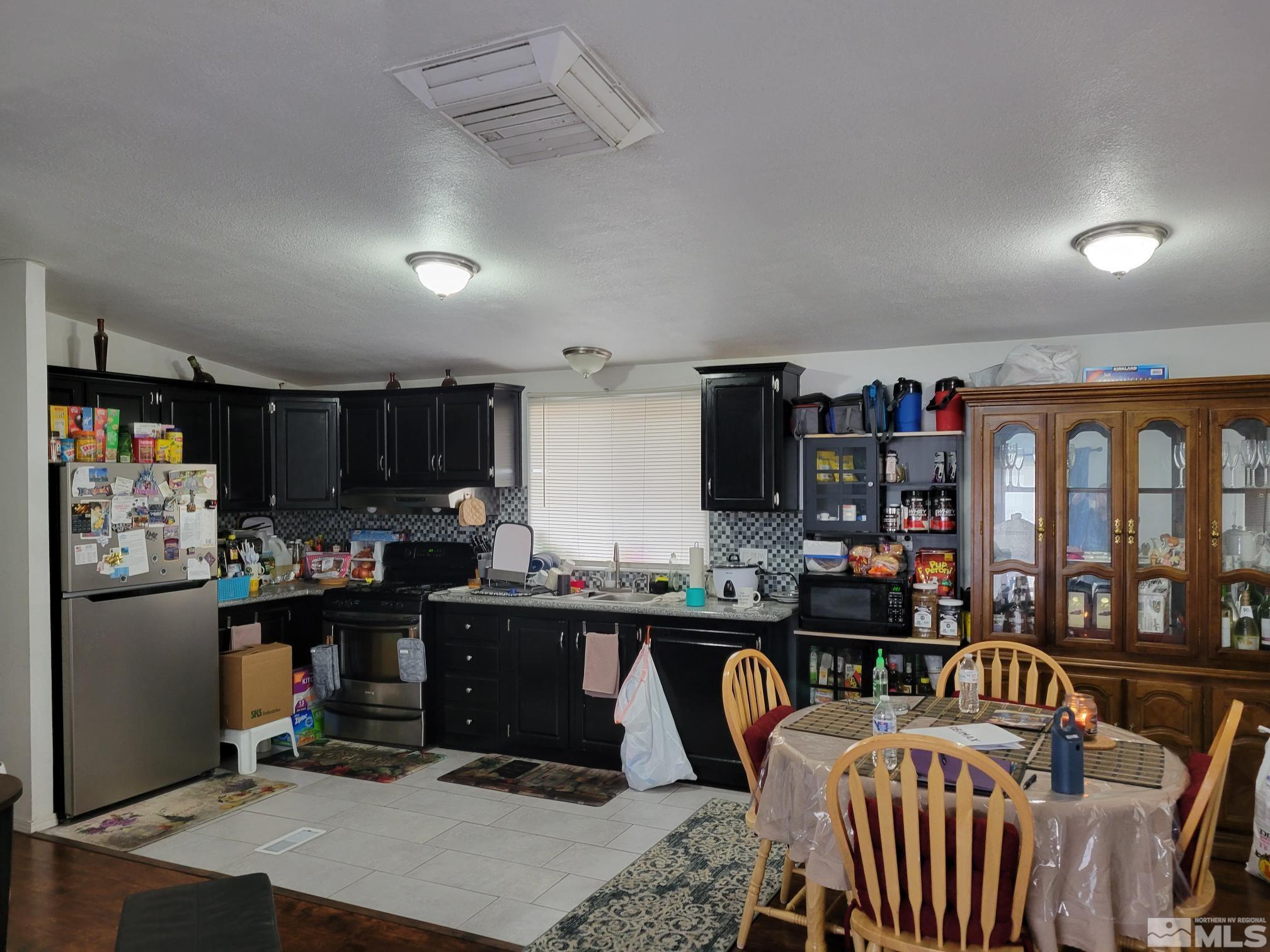 1348 Leopard Street Reno, NV 89506 - Photo 3 of 10 a kitchen with a table chairs refrigerator and cabinets