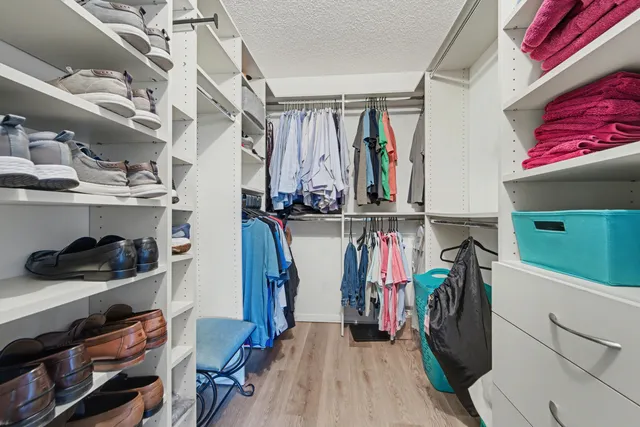 a view of walk in closet with clothes and shoes