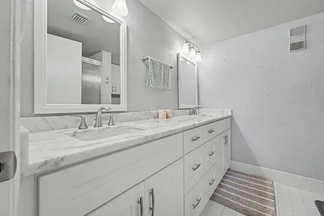 a bathroom with double sink and a mirror