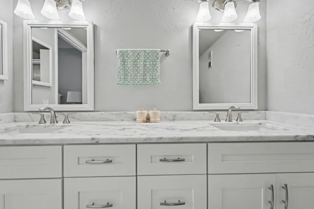 a bathroom with a granite countertop sink double and mirror