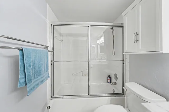 a bathroom with a shower a toilet and a sink