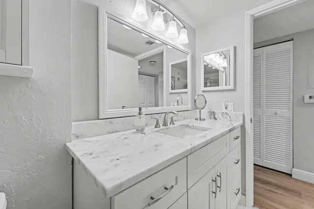 a bathroom with a granite countertop sink and a mirror
