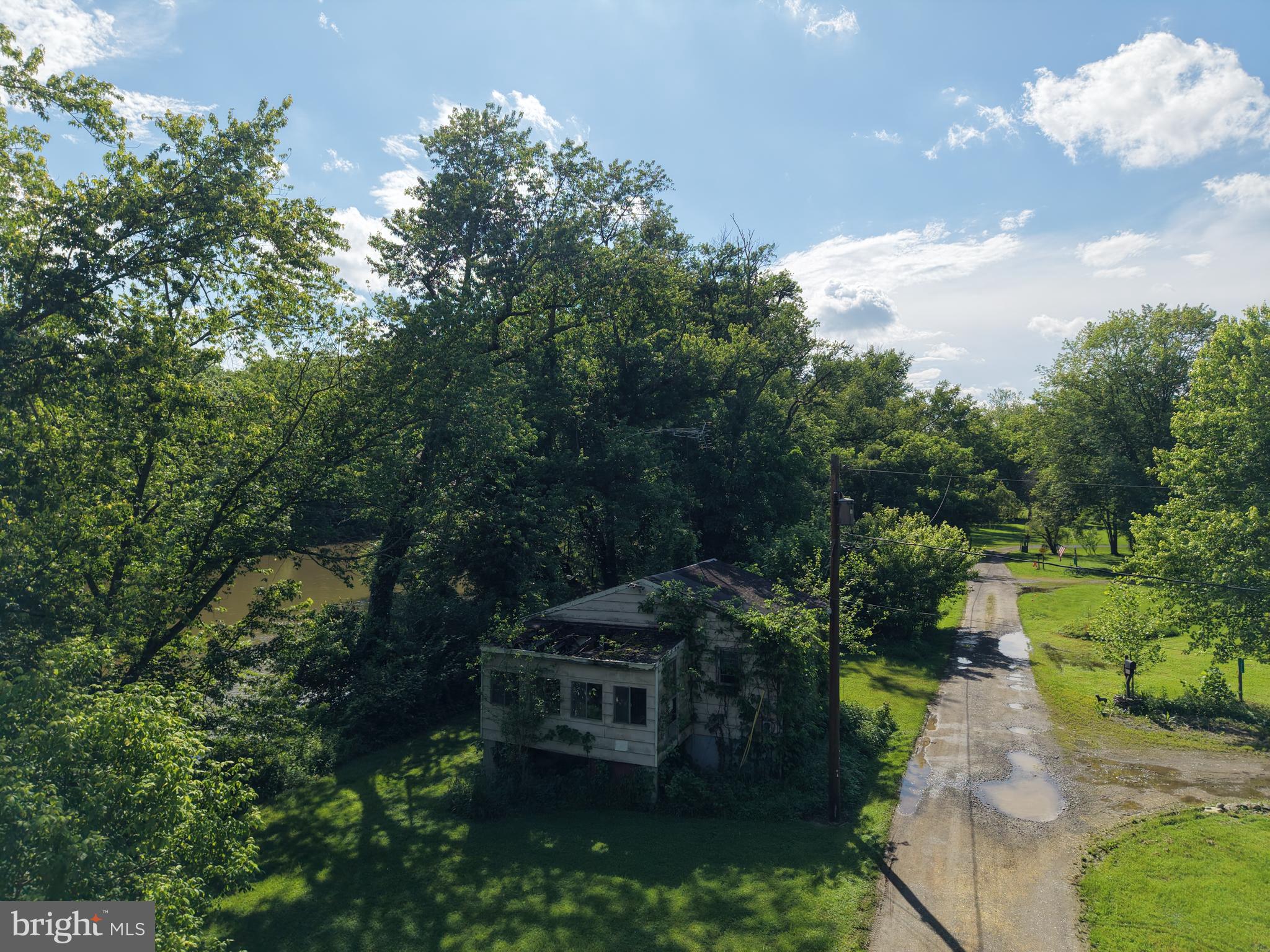 13726 Hopps Landing Road Hagerstown, MD 21740 - Photo 70 of 71 a view of a garden with lawn chairs under an umbrella