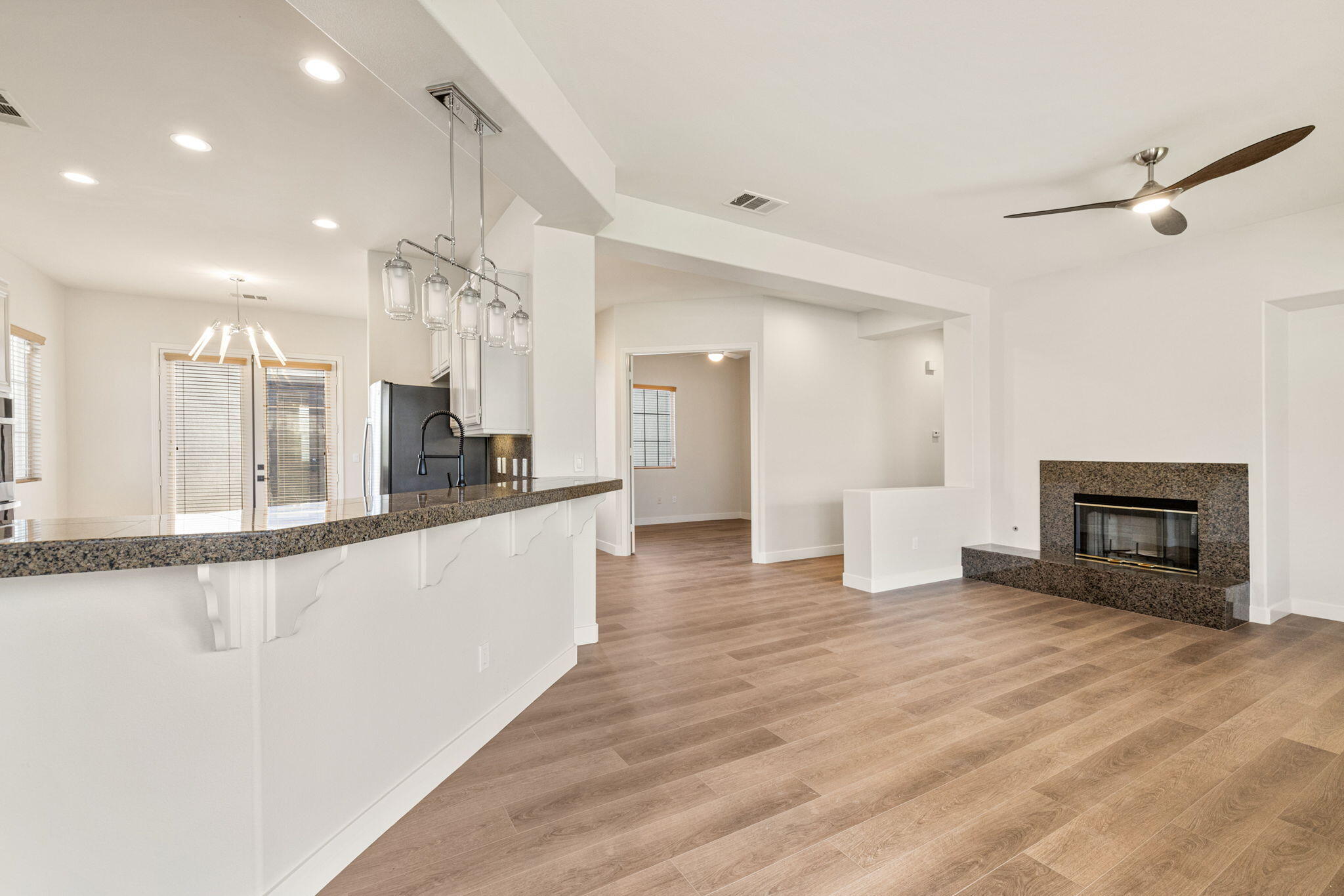 48537 Via Estacio Indio, CA 92201 - Photo 20 of 57 a large white kitchen with a sink and dishwasher a stove top oven with wooden floor