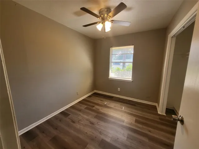 an empty room with a window and a fan