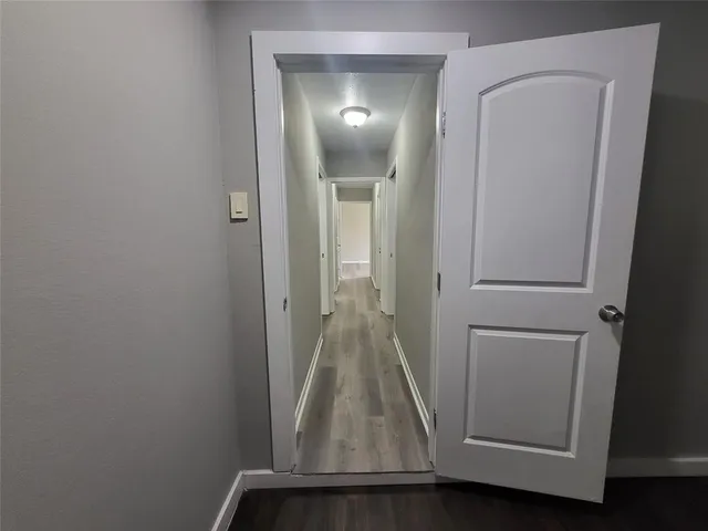 an empty room with wooden floor and entrance