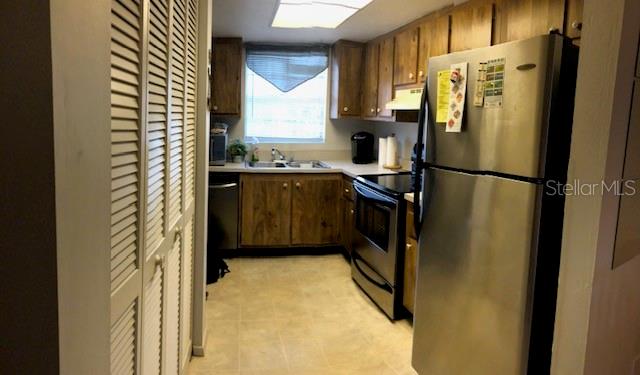 16881 Davis Road, Unit 723 Fort Myers, FL 33908 - Photo 3 of 13 a kitchen with stainless steel appliances granite countertop a refrigerator and a sink