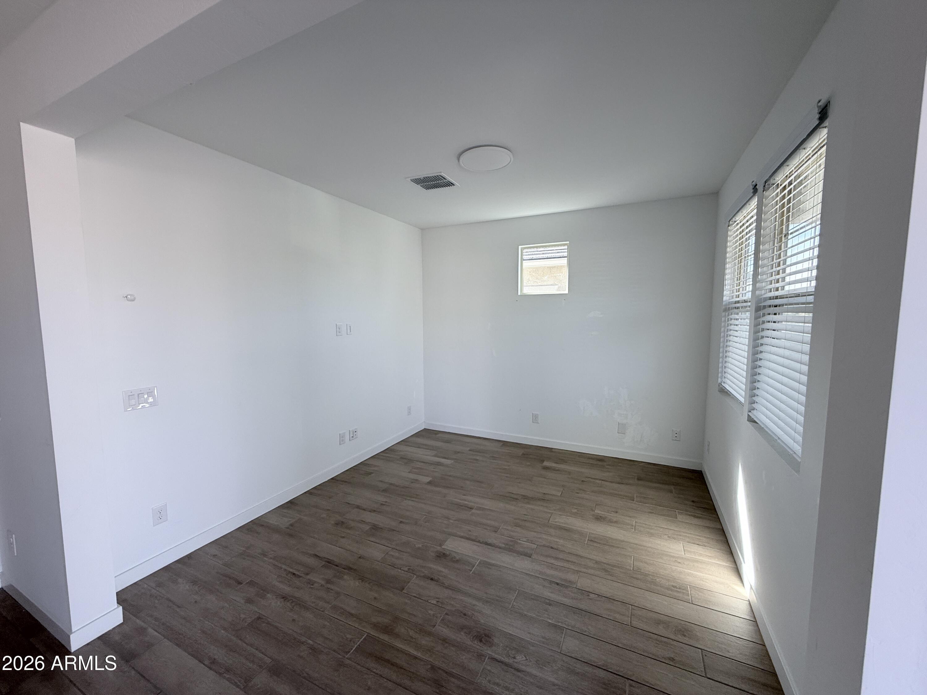 4323 West Palace Sta Road New River, AZ 85087 - Photo 4 of 20 an empty room with wooden floor and windows