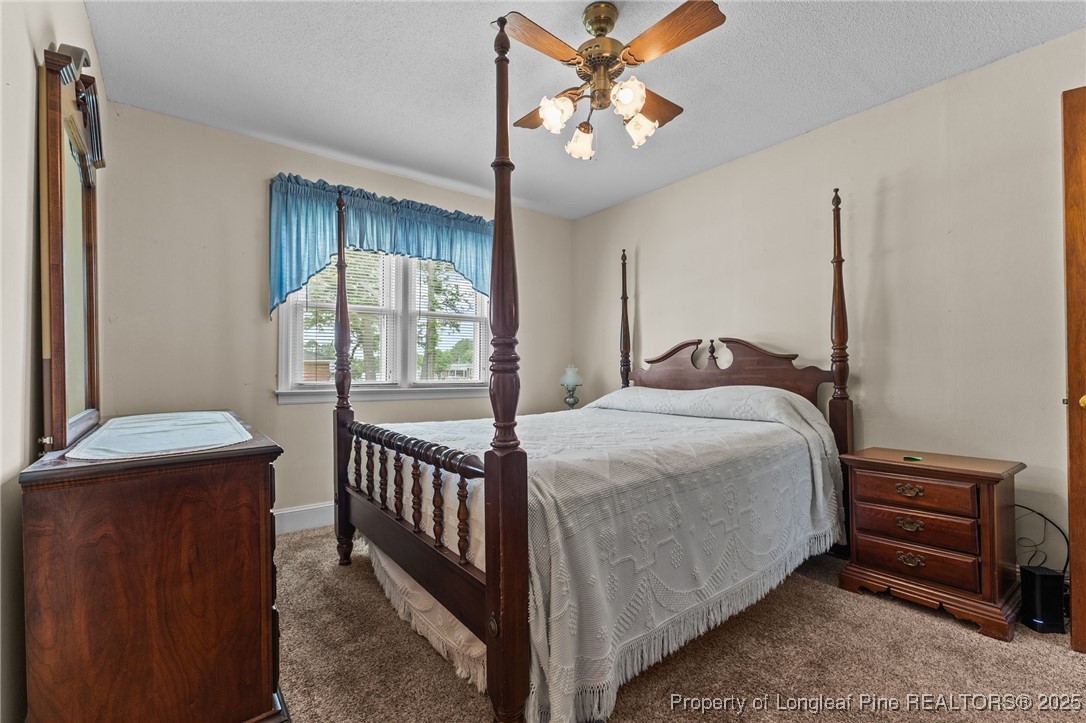 209 4th Street Erwin, NC 28339 - Photo 11 of 43 a bedroom with a bed and a chandelier
