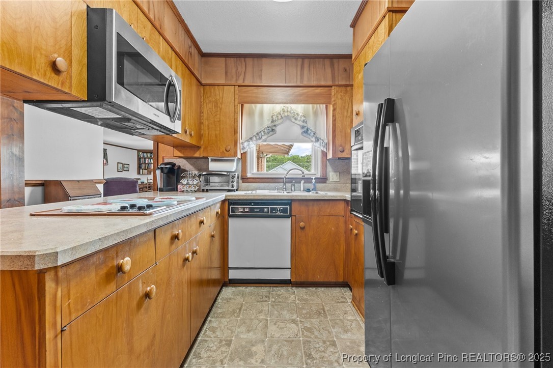 209 4th Street Erwin, NC 28339 - Photo 21 of 43 a kitchen with stainless steel appliances granite countertop a sink a stove and refrigerator