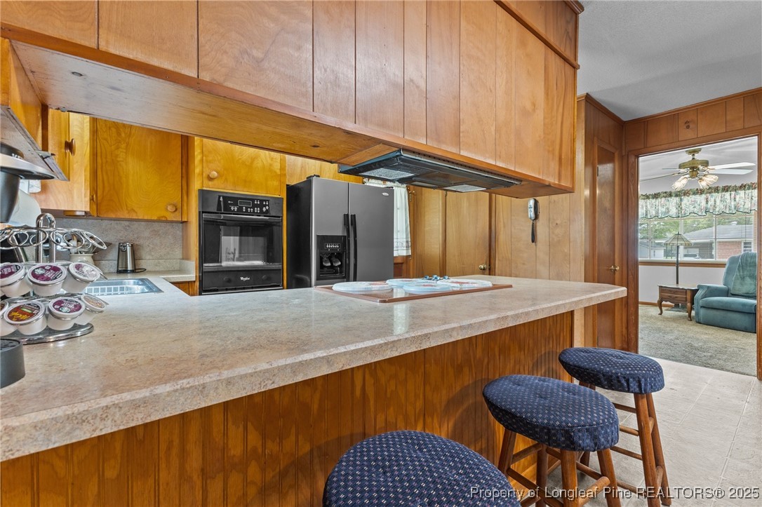 209 4th Street Erwin, NC 28339 - Photo 30 of 43 a view of a kitchen with kitchen island granite countertop wooden cabinets a stove a sink and a large window