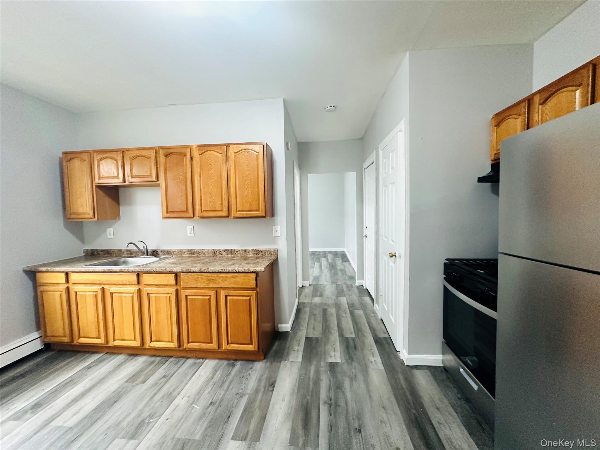 7 Franklin Street, Unit #7 Poughkeepsie, NY 12601 - Photo 4 of 11 a kitchen with stainless steel appliances granite countertop a refrigerator a stove and a sink with wooden floor