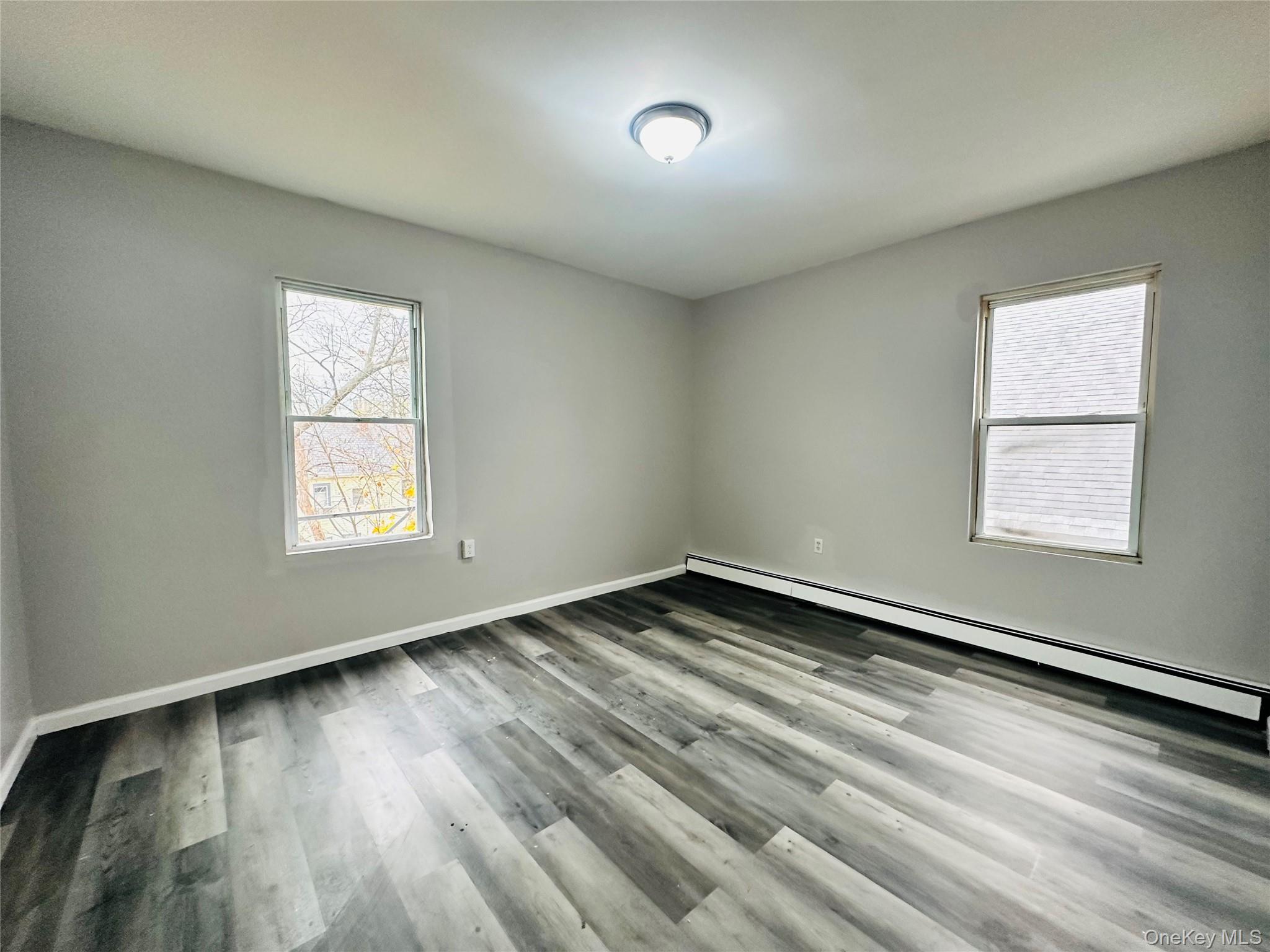 7 Franklin Street, Unit #7 Poughkeepsie, NY 12601 - Photo 10 of 11 an empty room with wooden floor and windows