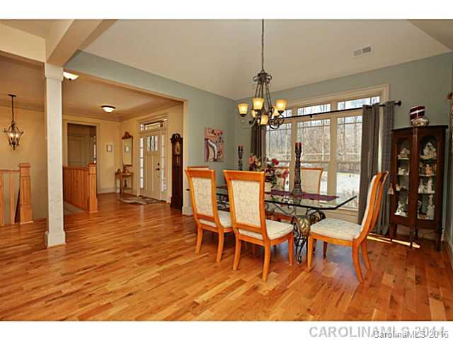 3457 Harmony Road Catawba, SC 29704 - Photo 3 of 24 a dining room with wooden floor a chandelier a glass table and chairs