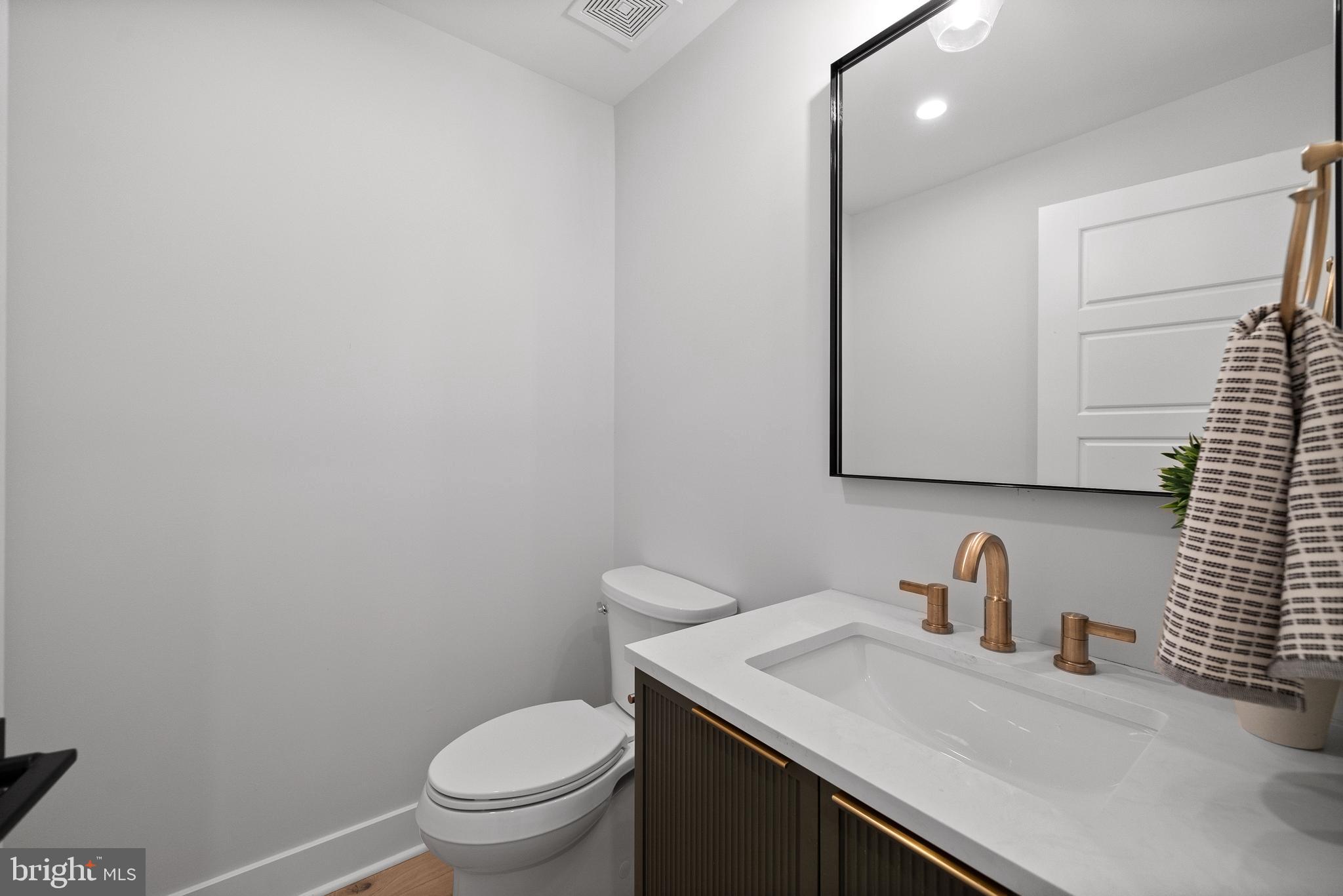 827 Weadley Road Wayne, PA 19087 - Photo 41 of 96 a bathroom with a granite countertop sink vanity mirror and toilet