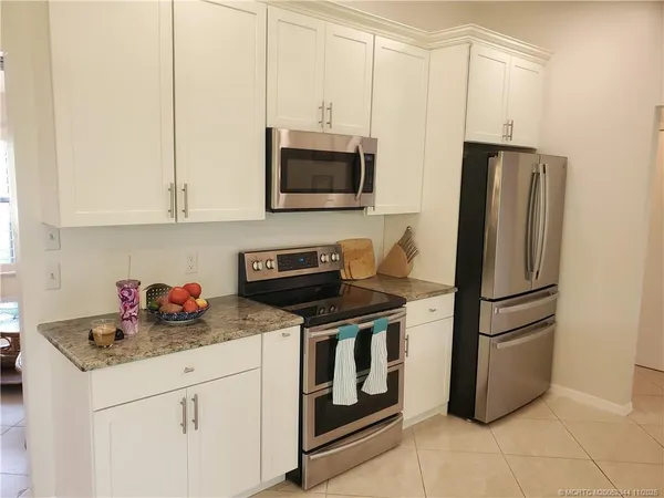 a kitchen with stainless steel appliances granite countertop a refrigerator stove and microwave