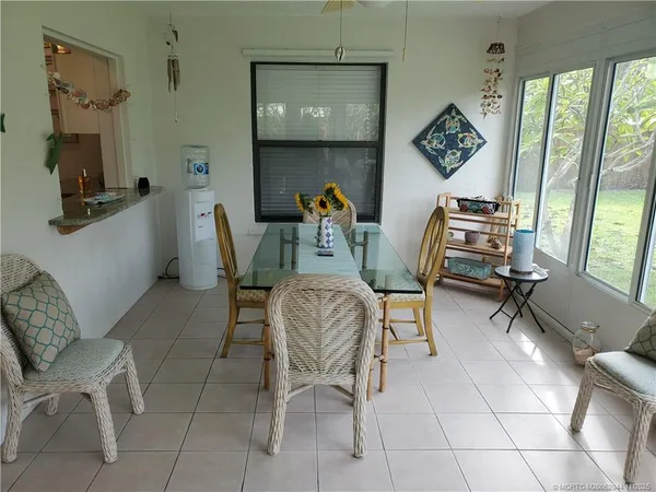 a dining room with furniture and a floor to ceiling window