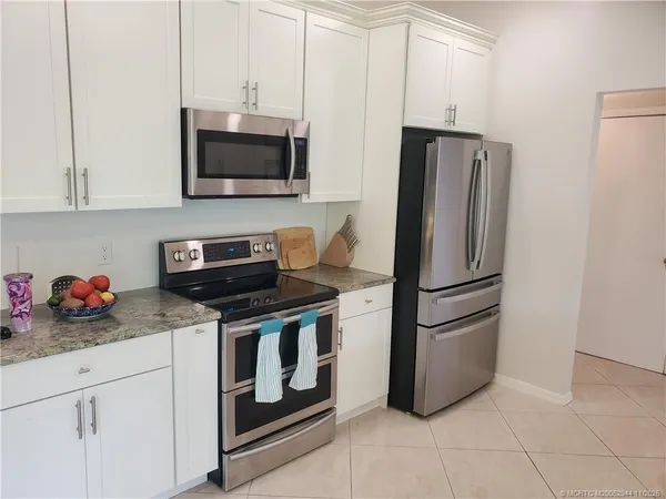 a kitchen with stainless steel appliances a stove microwave and refrigerator