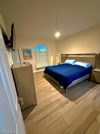 a bedroom with a bed and a flat screen tv
