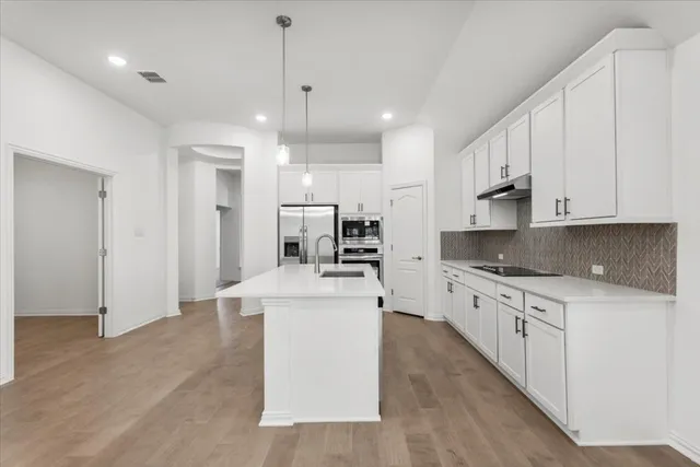 a large kitchen with stainless steel appliances lots of counter top space
