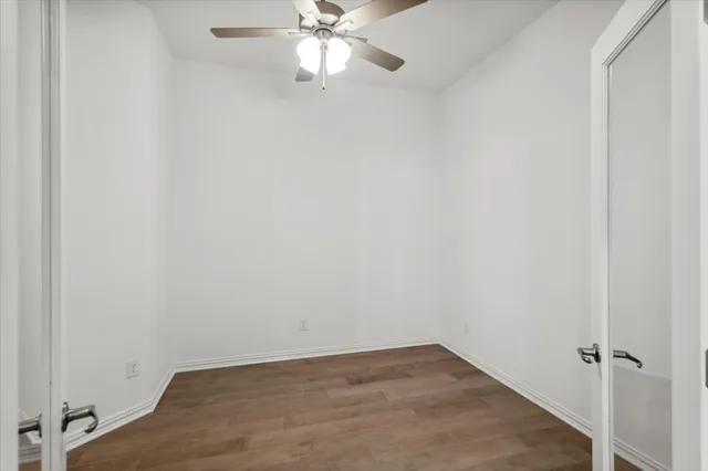 an empty room with a fan and a fan