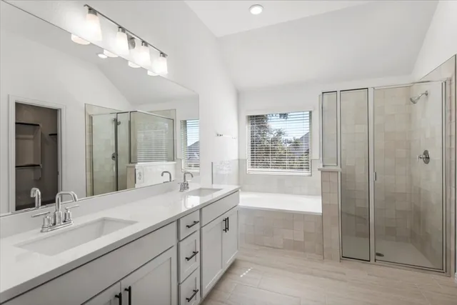 a spacious bathroom with a double vanity sink a mirror and a bathtub