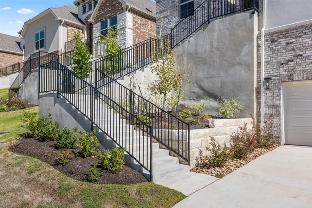 a view of a house with a small yard and potted plants