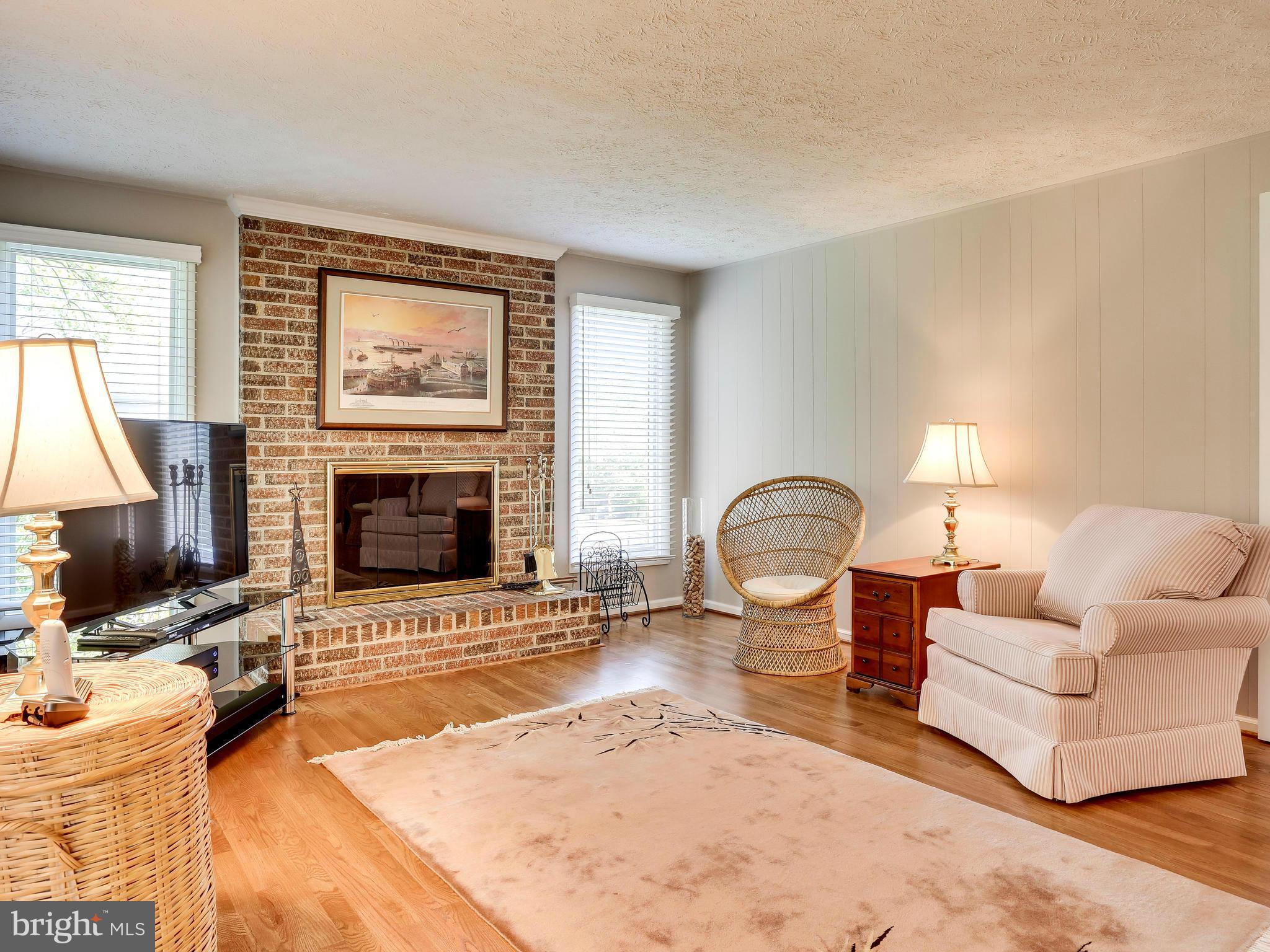 7569 Vogels Way Springfield, VA 22153 - Photo 13 of 28 a living room with furniture a flat screen tv and a fireplace