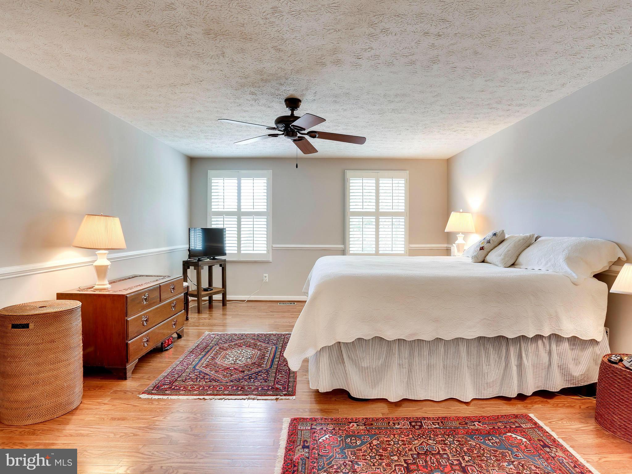 7569 Vogels Way Springfield, VA 22153 - Photo 18 of 28 a spacious bedroom with a bed and a chandelier