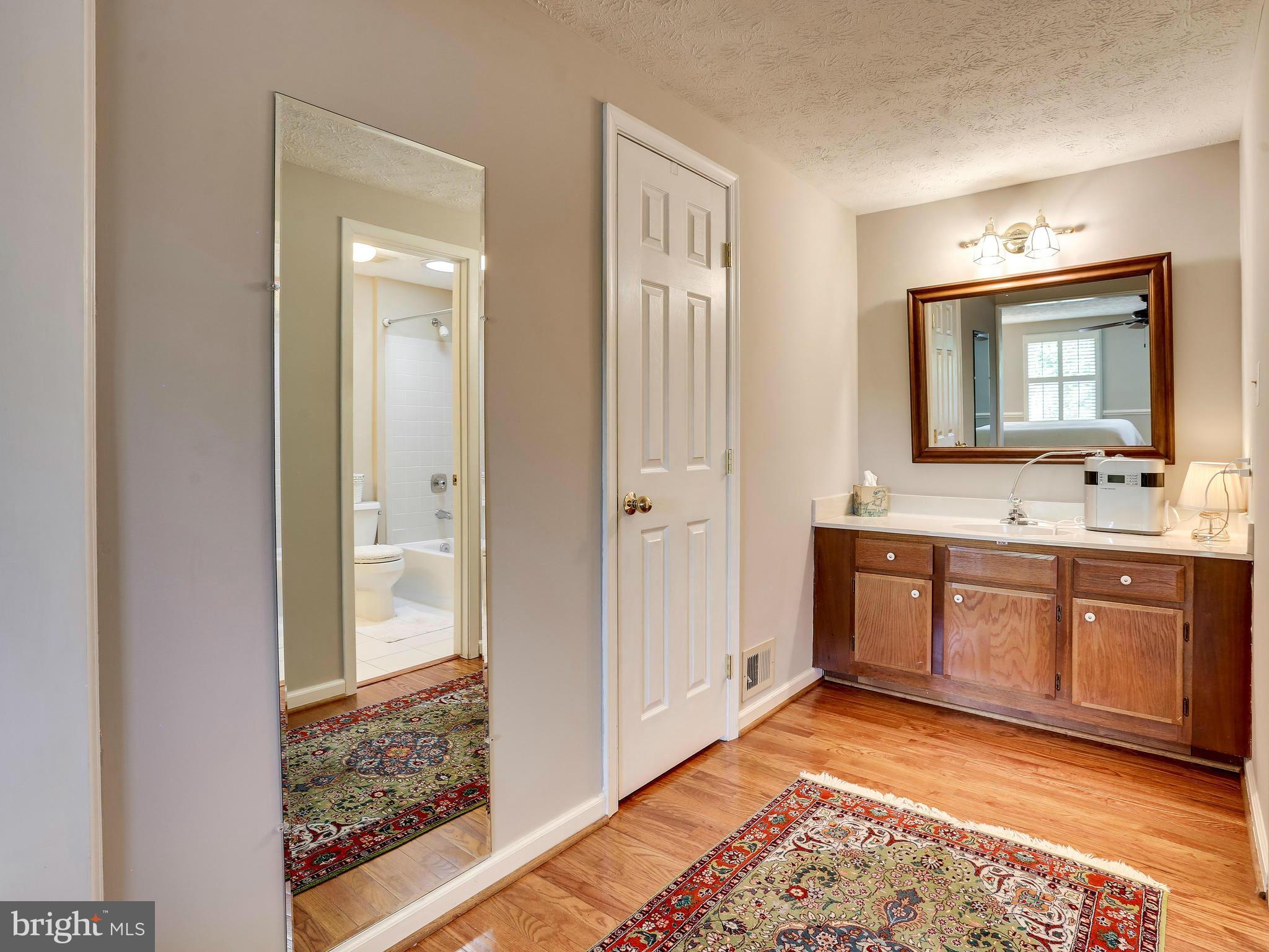7569 Vogels Way Springfield, VA 22153 - Photo 23 of 28 a spacious bathroom with a mirror sink and toilet