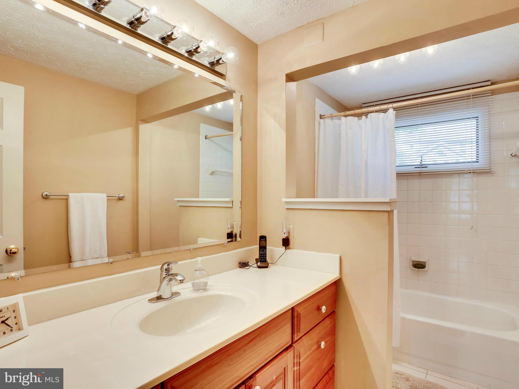 7569 Vogels Way Springfield, VA 22153 - Photo 24 of 28 a bathroom with a granite countertop sink and a mirror