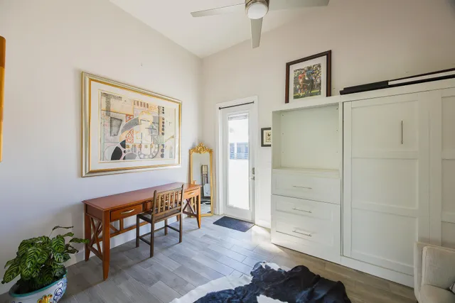 a view of a hallway with wooden floor and closet