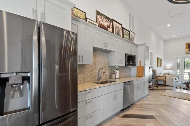 a kitchen with stainless steel appliances a refrigerator sink and cabinets