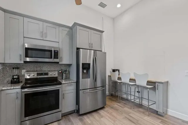 a kitchen with stainless steel appliances a refrigerator microwave and sink