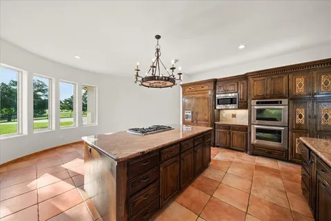 a large kitchen with granite countertop a large stove a sink dishwasher and a refrigerator