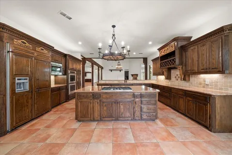a large kitchen with stainless steel appliances kitchen island granite countertop a sink and cabinets