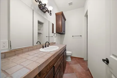 a large bedroom with a large bed and a flat tv screen