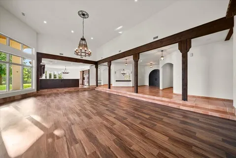 a large room with chandelier fan and windows