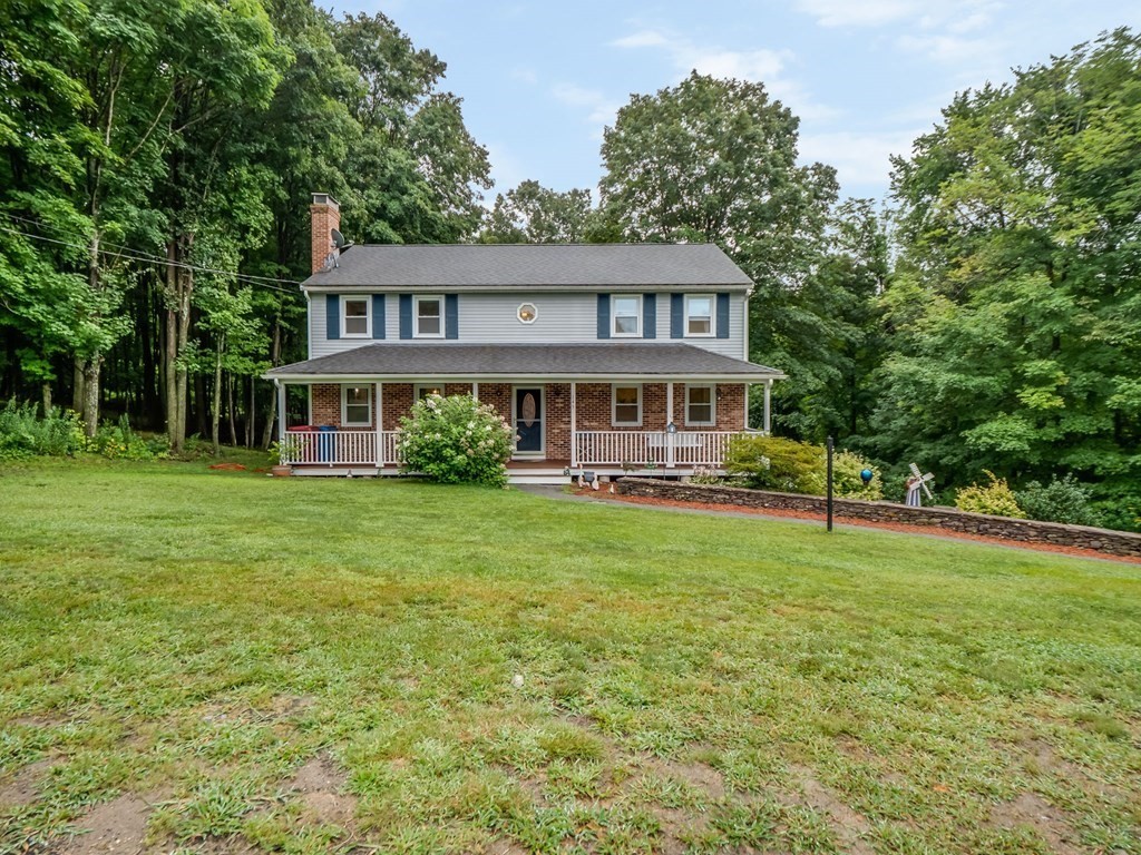 a front view of a house with a yard table and trees