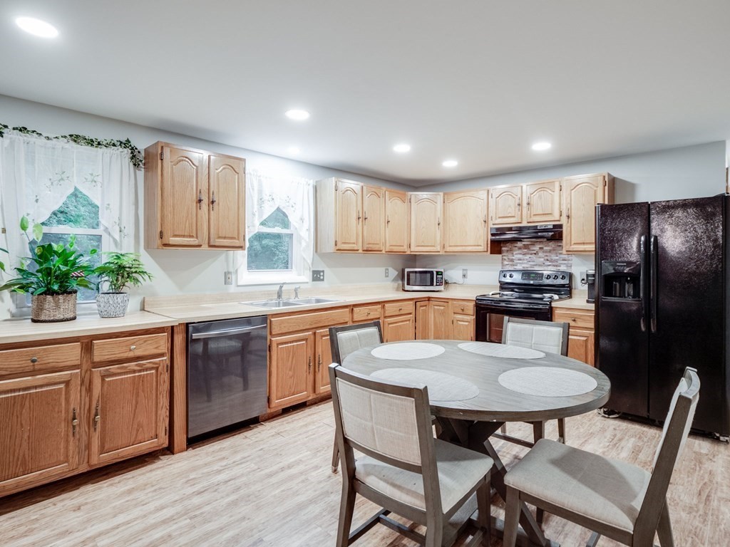 145 Coburn Road Tyngsborough, MA 01879 - Photo 11 of 41 a kitchen with granite countertop white cabinets and stainless steel appliances