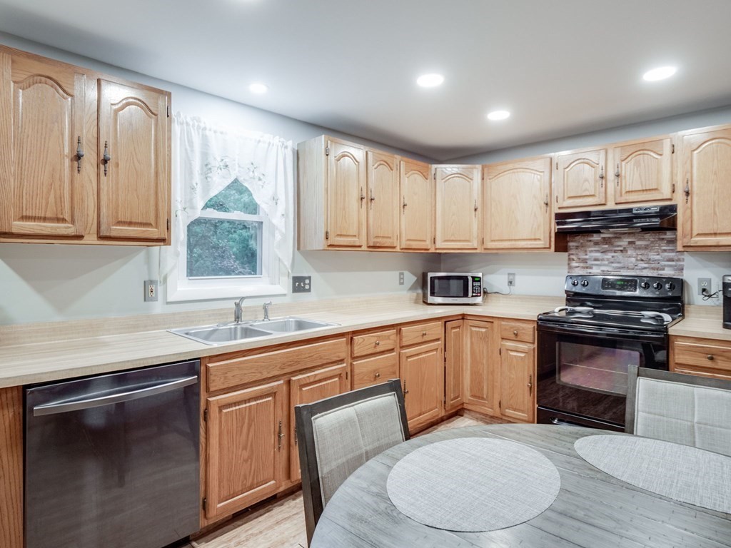 145 Coburn Road Tyngsborough, MA 01879 - Photo 12 of 41 a kitchen with stainless steel appliances granite countertop a stove a sink dishwasher and a microwave oven with cabinets