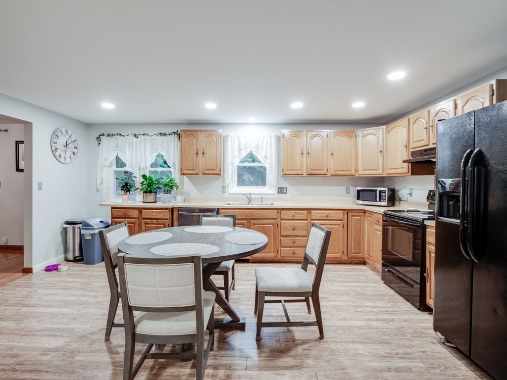145 Coburn Road Tyngsborough, MA 01879 - Photo 13 of 41 a kitchen with stainless steel appliances a dining table chairs refrigerator and microwave