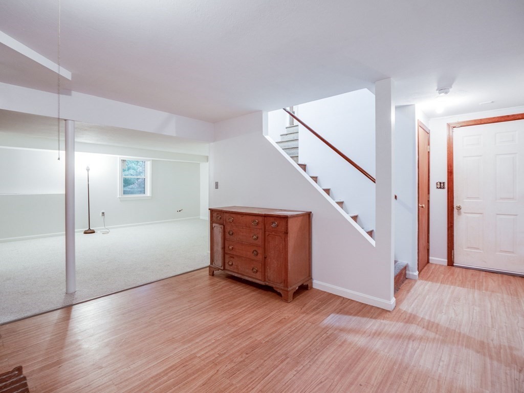 145 Coburn Road Tyngsborough, MA 01879 - Photo 30 of 41 a view of an empty room with wooden floor and stairs