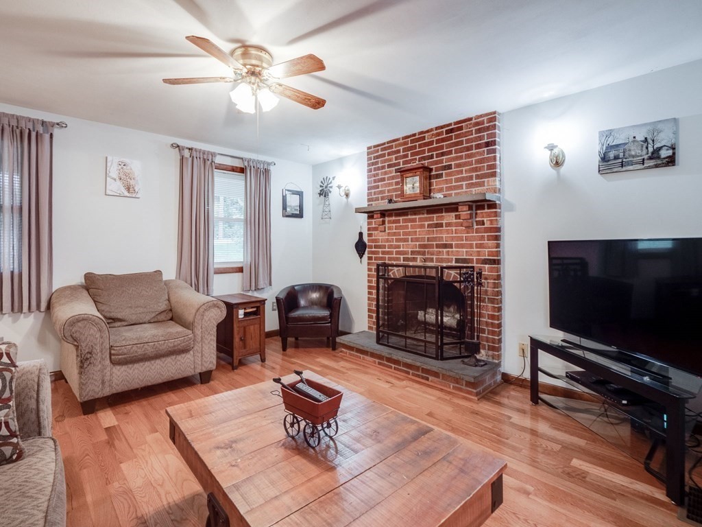 145 Coburn Road Tyngsborough, MA 01879 - Photo 6 of 41 a living room with furniture a flat screen tv and a fireplace