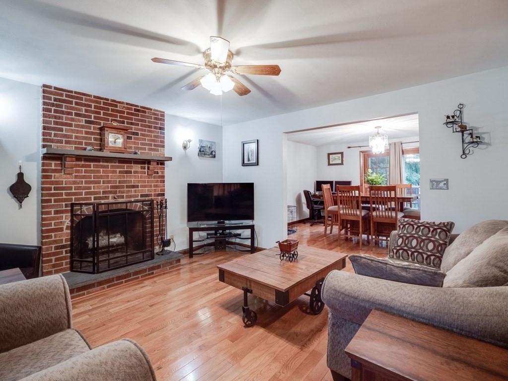 145 Coburn Road Tyngsborough, MA 01879 - Photo 7 of 41 a living room with furniture a fireplace and a flat screen tv